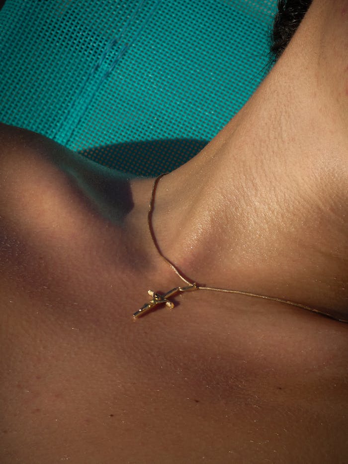 Mastering the First Impression: Your intriguing post title goes here Minimalist gold cross necklace resting on a person's neck in close-up.